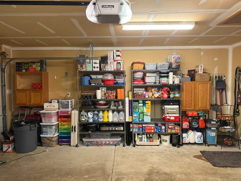 Same shelving wall after, with household supplies and belongings grouped on reused shelves