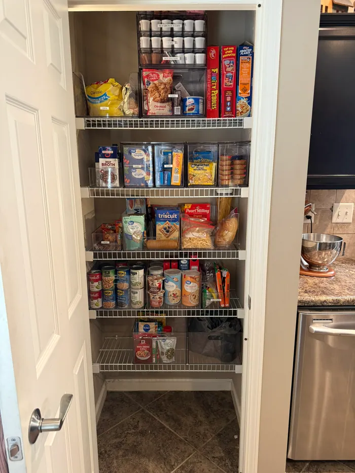 Completed client pantry with food grouped in clear bins and an open floor